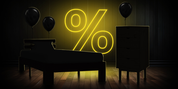  Μαύρο κρεβάτι και συρταριέρα με μαύρα μπαλόνια μπροστά από ένα φωτεινό κίτρινο σημάδι ποσοστού σε σκούρο ξύλινο πάτωμα.